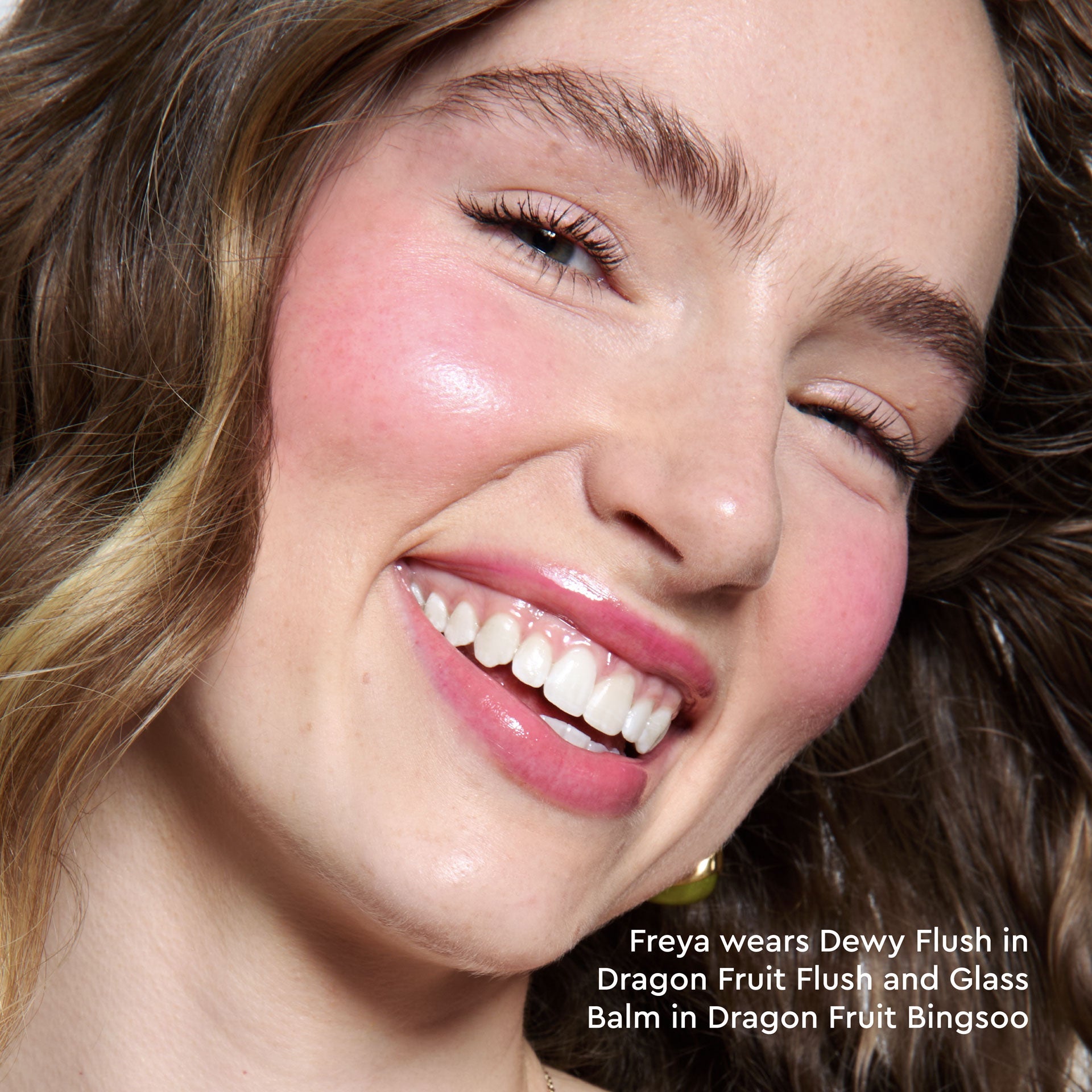 A model's cheeks are shown flushed with Dragon Fruit Flush in a close-up on-face application shot.