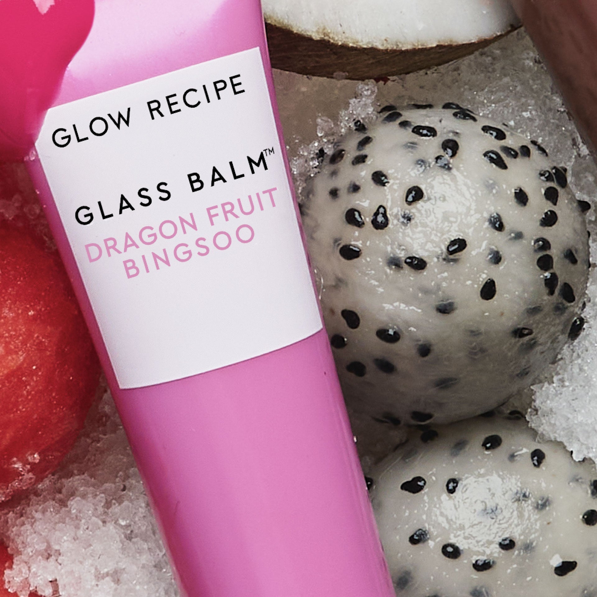 Lifestyle shot pairing the Glass Balm tube in Dragon Fruit Bingsoo with fresh dragon fruit slices.