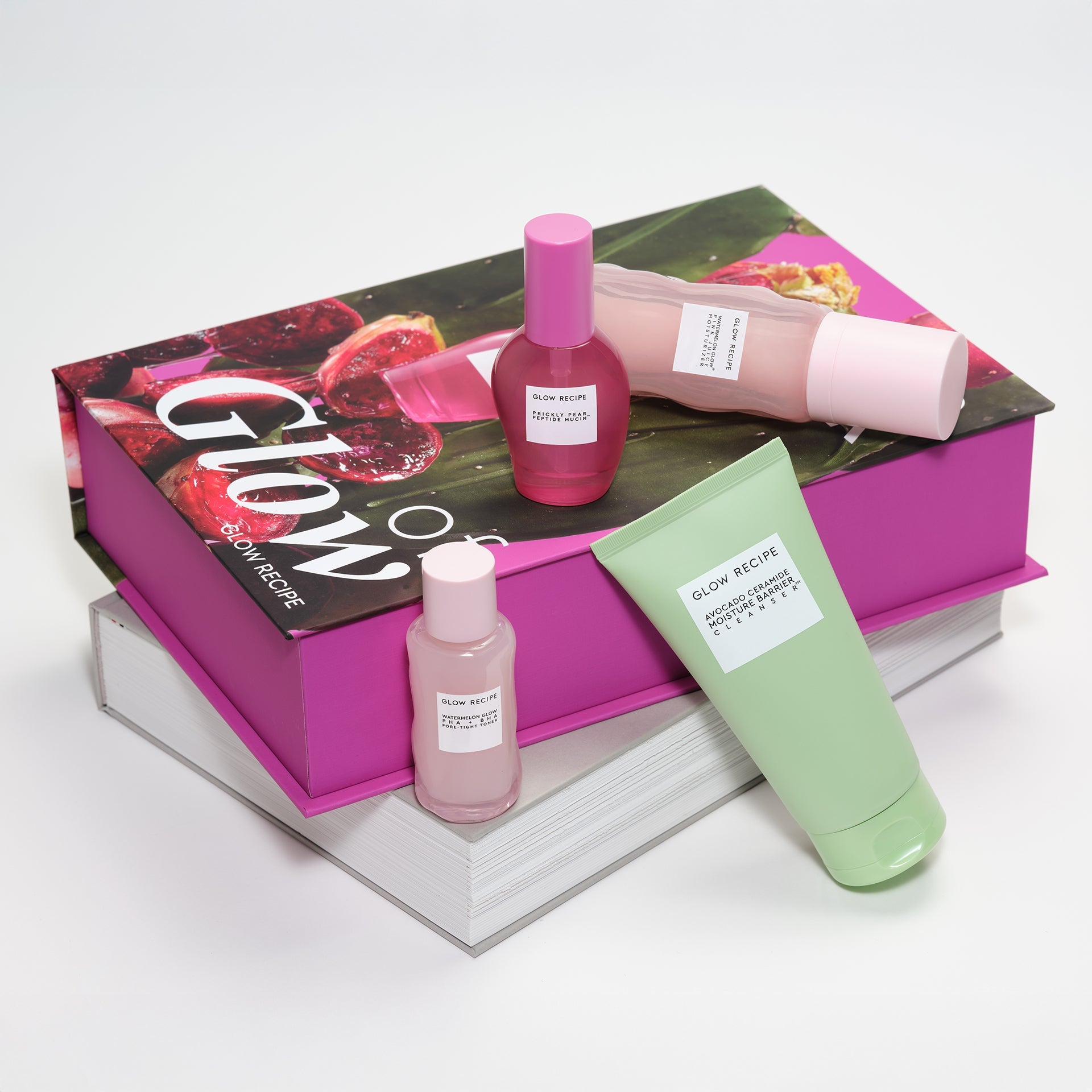 Skincare products including a pink bottle and green tube on a 'Glow' branded box.