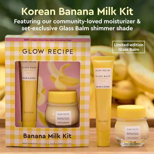 Glow Recipe Banana Milk Kit with packaging, glass balm, and cream on a wooden surface with banana background.
