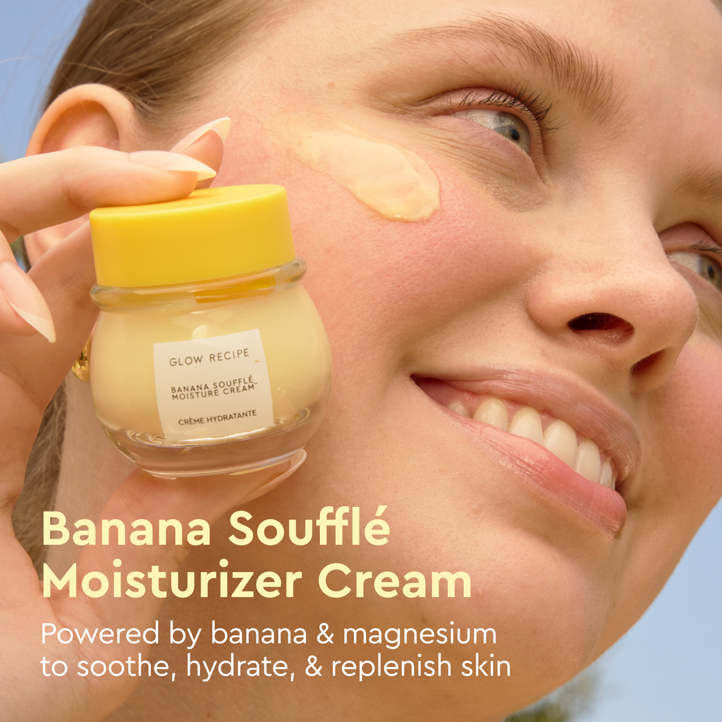 Woman applying Banana Souffle Moisturizer Cream to her face with a clear blue sky background