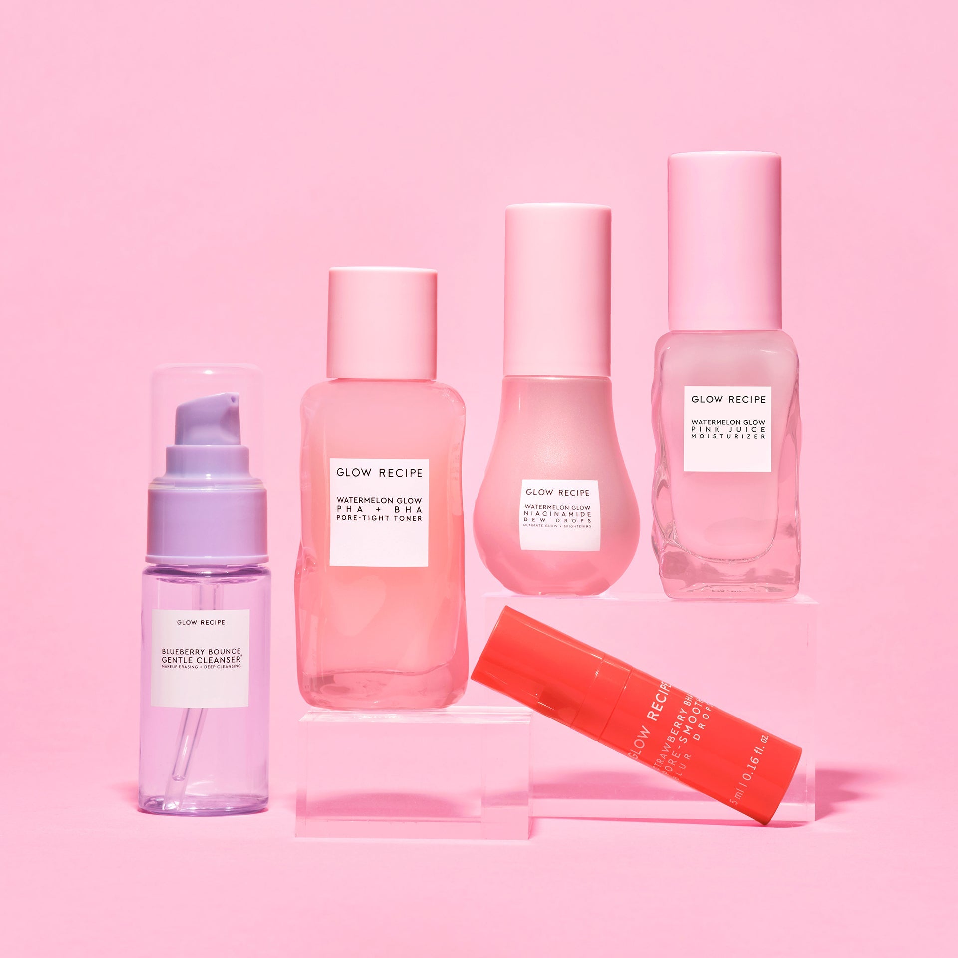 Clear Skin Essentials five-piece kit shot with the mini cleanser, toner, blur drops, dew drops, and moisturizer on pink.
