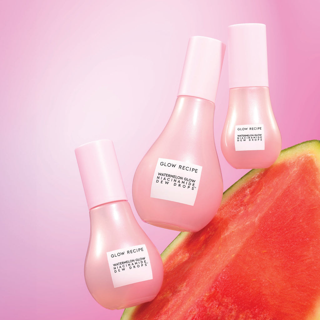 Three sized bottles of Glow Recipe Niacinamide Dew Drop Bottles on watermelon and pink background.