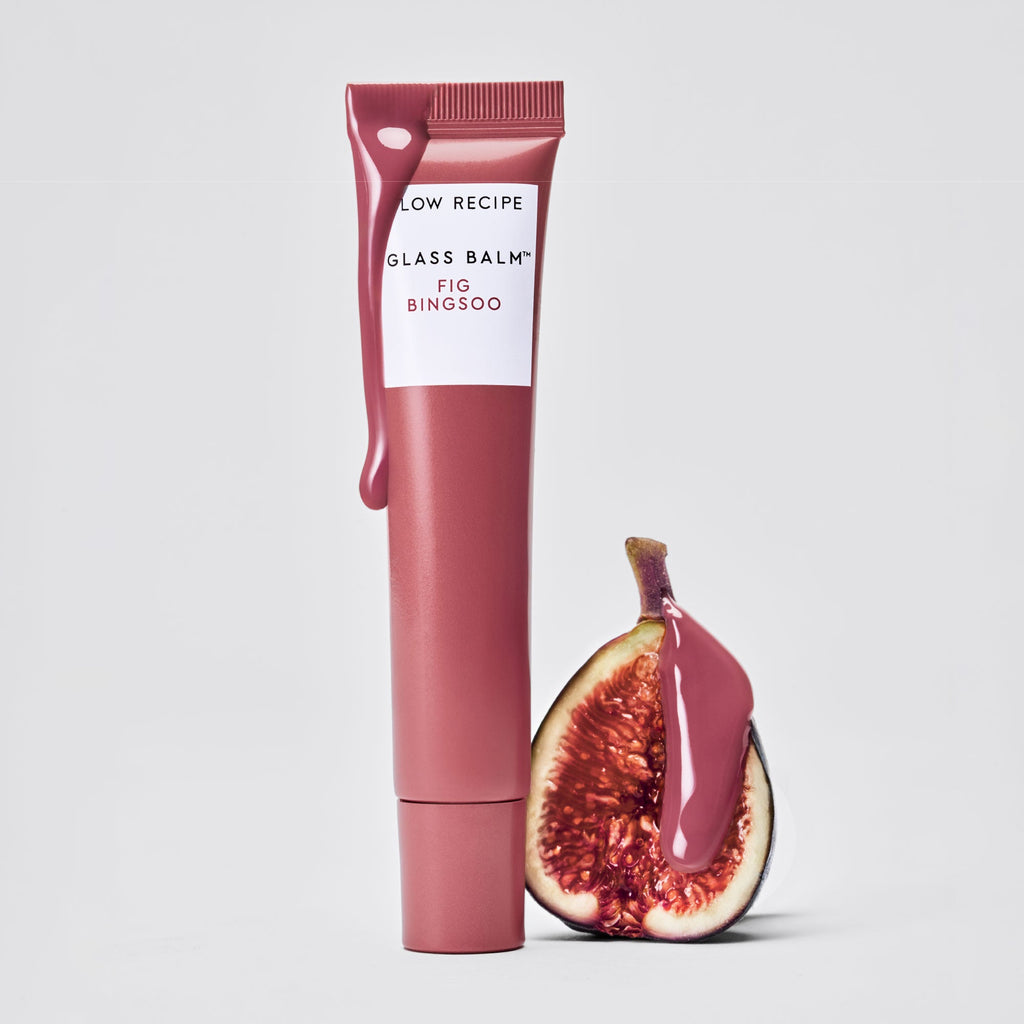 Glass Balm tube in Fig Bingsoo staged beside fresh fig fruit to illustrate the fruit-powered formula.