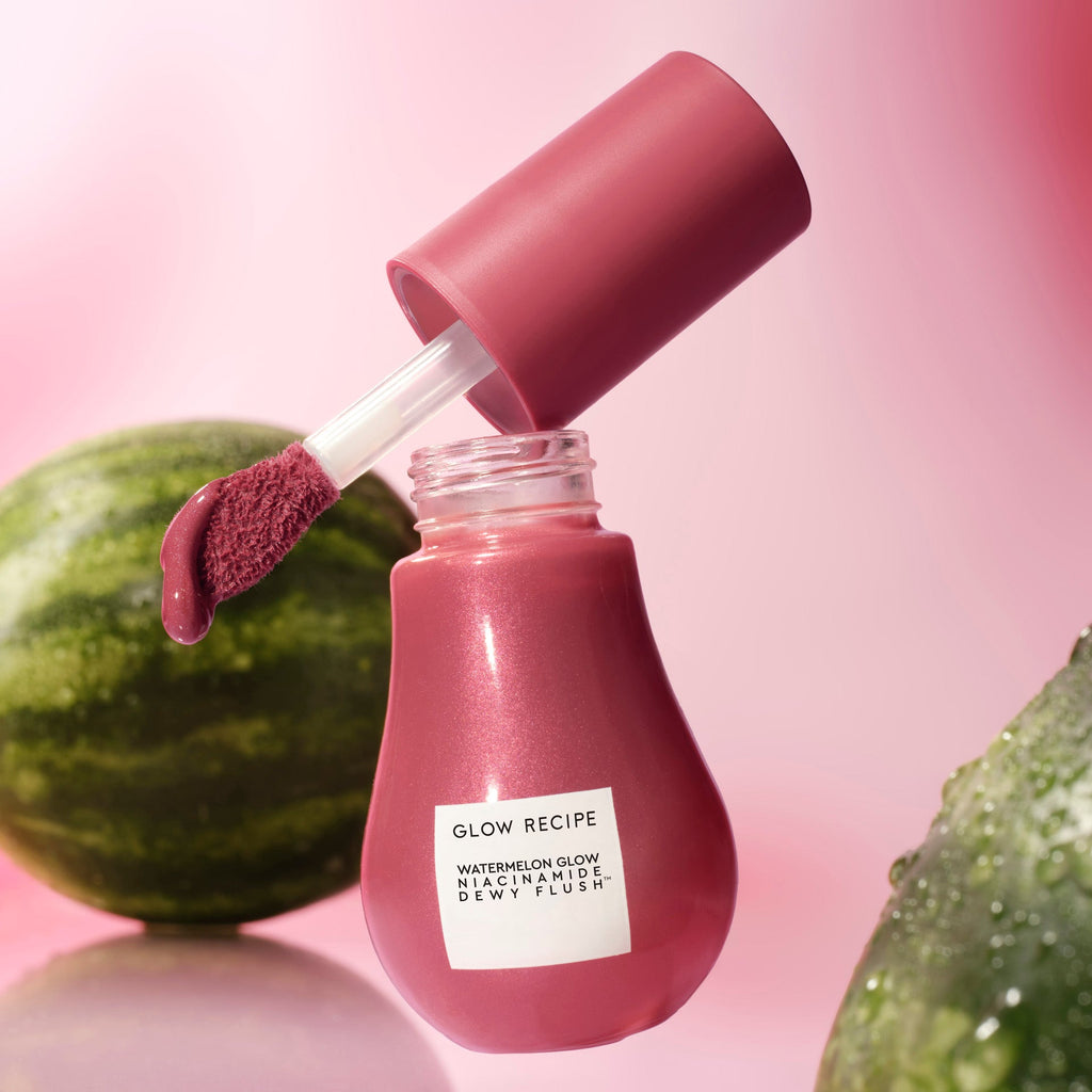 A studio shot of the Dewy Flush bottle in Berry Flush is angled to show its warm berry plum tinted serum.
