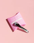 Pink pouch with a skin care spatula on a pink background, featuring 'Glow Recipe' branding.