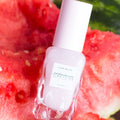 Skincare bottle with watermelon slices in the background