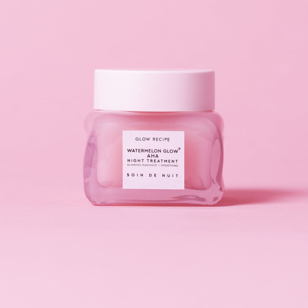 Pink skincare jar with white label on a pink background